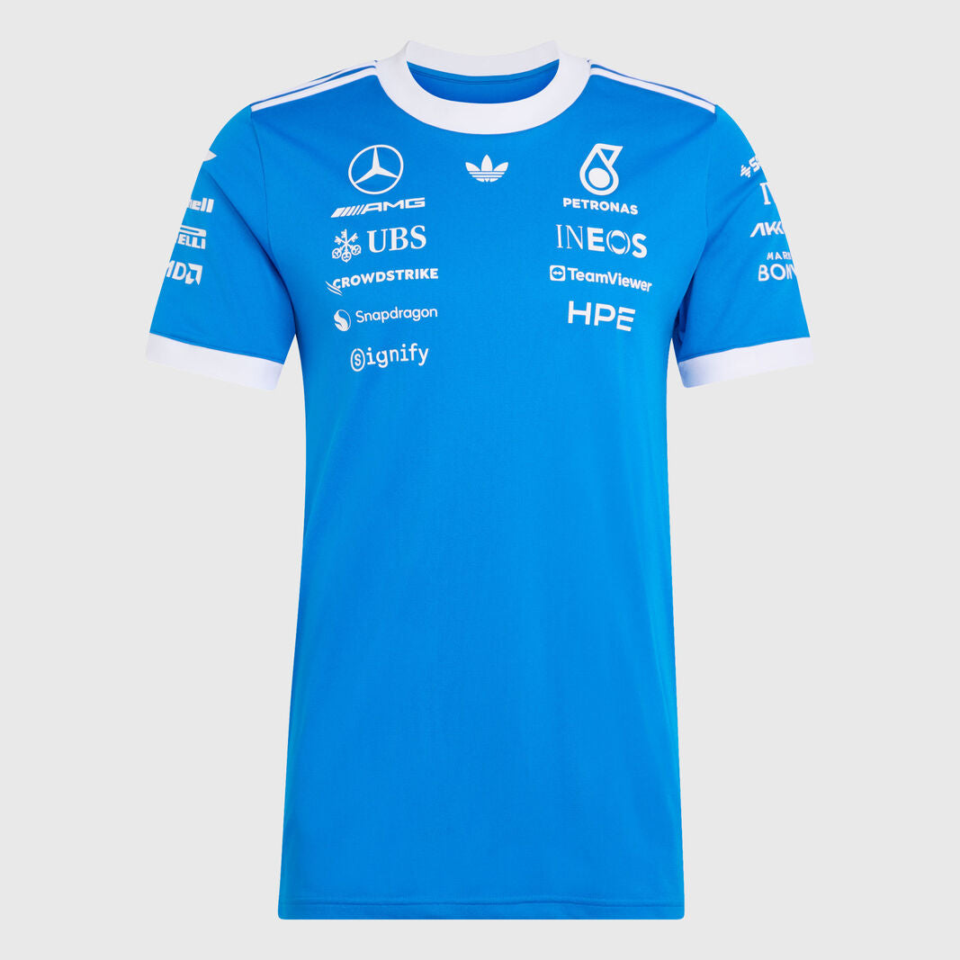 A bright blue Mercedes Formula 1 team t-shirt with white sponsor logos and white trim on the collar and cuffs, displayed against a light gray background.