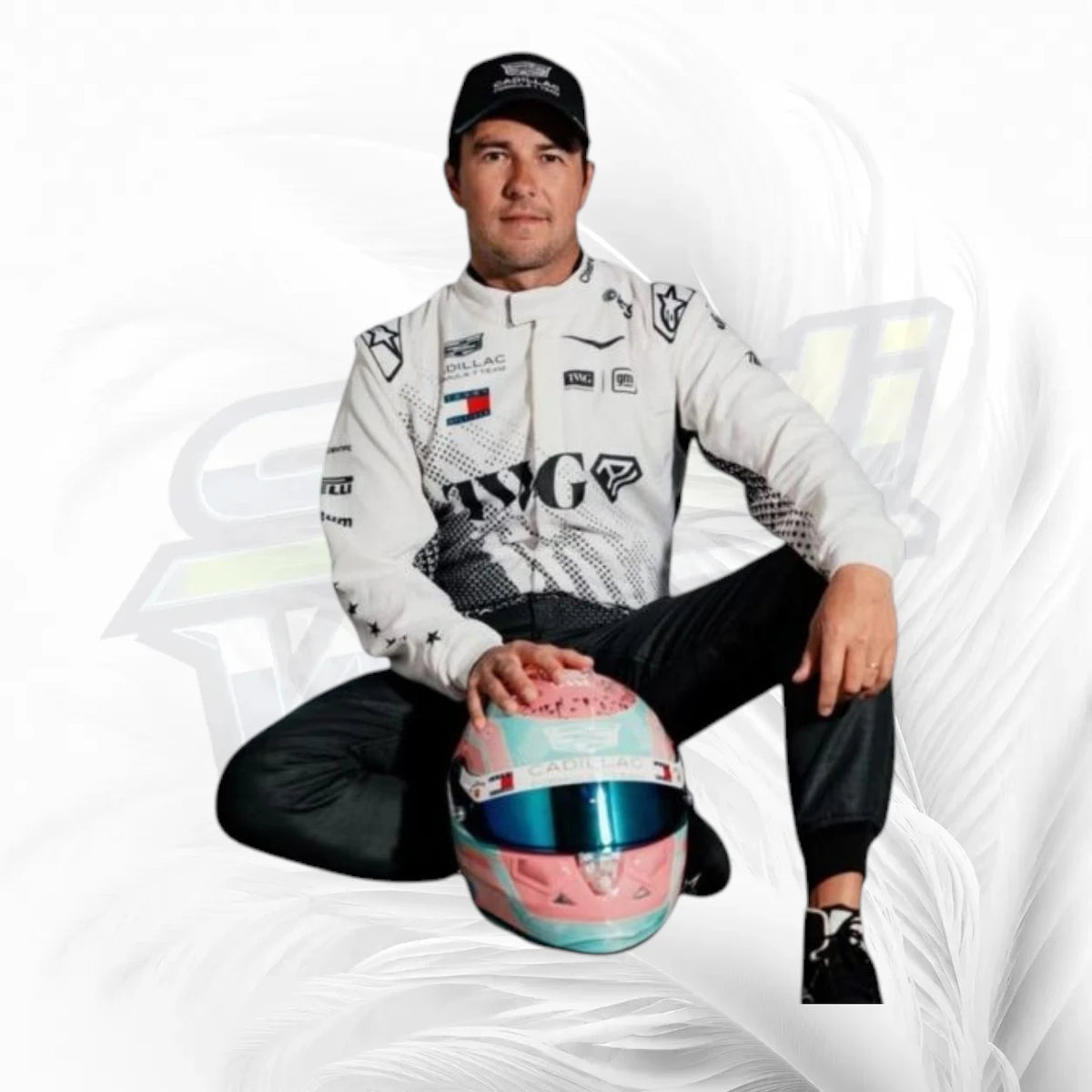 A man in a white racing suit and black cap sits cross-legged on a white background, holding a pink and blue racing helmet. The suit features multiple sponsor logos including Tommy Hilfiger and Piquadro.