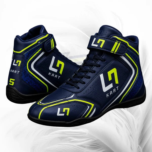 Pair of navy blue racing shoes with green accents on a white background